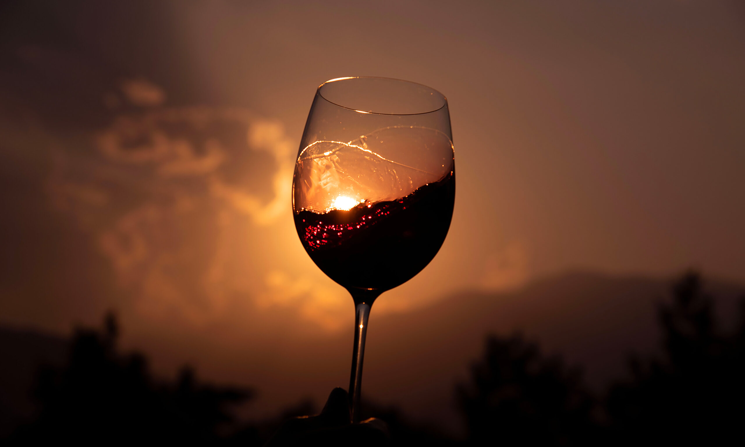 Calice di vino rosso esposto al sole calante